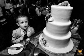 Guest's Enchanting Glance Captured at Romantic Bradley Inn Wedding in New Harbor, Maine A young guest's gaze is captured by the elegant wedding cake on display at a Bradley Inn wedding in New Harbor, Maine.